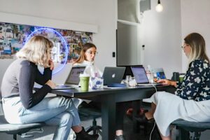 Two ladies and a guy using laptops