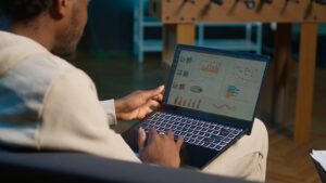 african american freelancer working from home using financial graphs