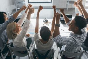 Team of marketers jubilating after winning back major cold leads